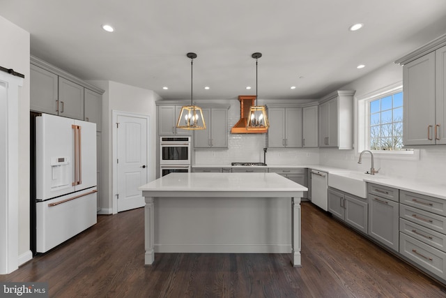 kitchen with premium range hood, stainless steel appliances, a kitchen island, and dark hardwood / wood-style flooring