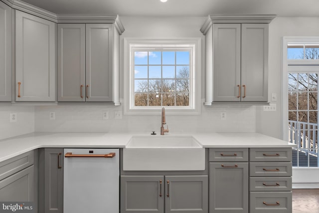 kitchen featuring gray cabinets, dishwasher, and sink