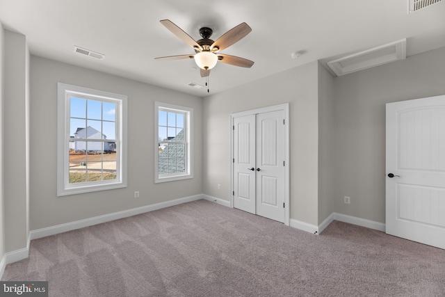 unfurnished bedroom with light colored carpet, a closet, and ceiling fan