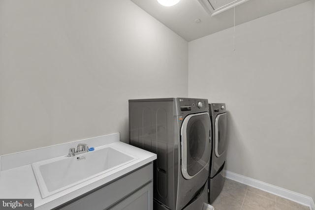 clothes washing area featuring sink, washing machine and dryer, and light tile patterned floors