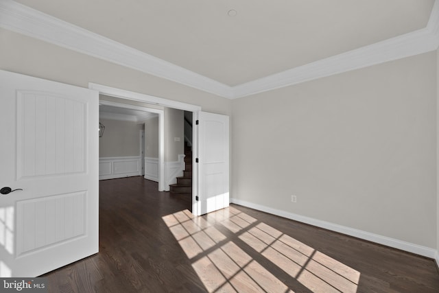 spare room with crown molding and dark wood-type flooring