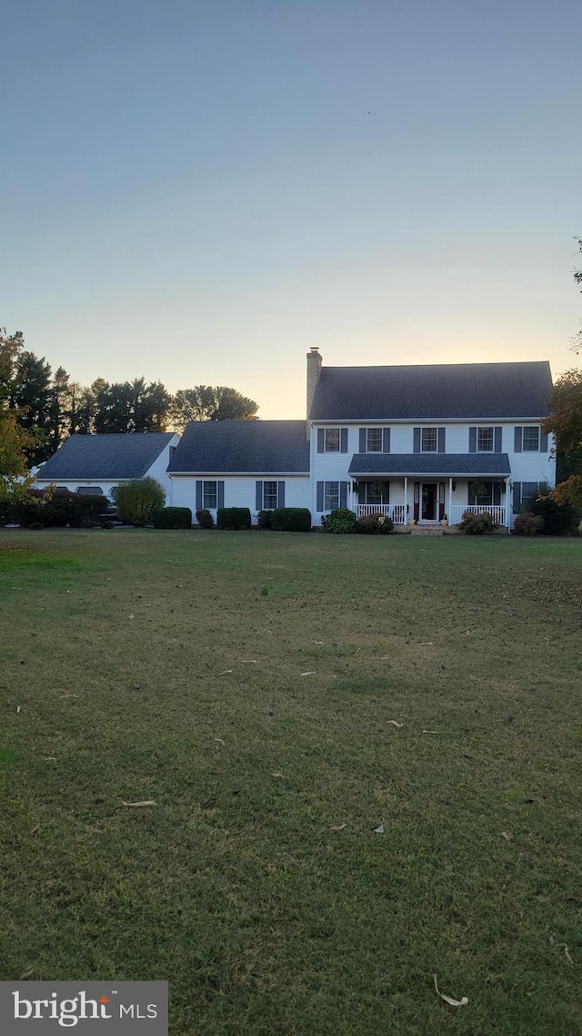 view of front facade featuring a wooden deck and a lawn