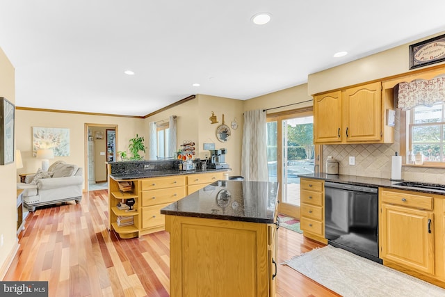 kitchen featuring black dishwasher, backsplash, a center island, dark stone counters, and light hardwood / wood-style flooring