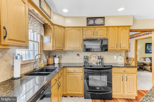 kitchen featuring sink, backsplash, black appliances, and light hardwood / wood-style flooring