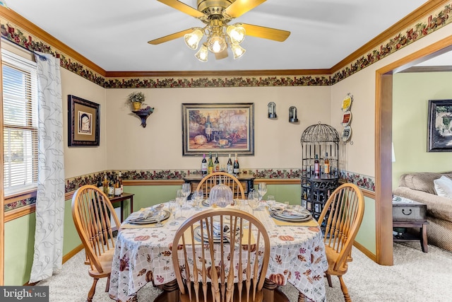 dining space featuring crown molding, carpet flooring, and ceiling fan