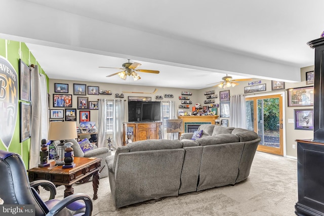 carpeted living room featuring ceiling fan and beam ceiling