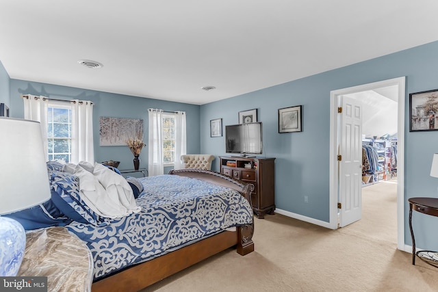 carpeted bedroom featuring a closet, multiple windows, and a spacious closet