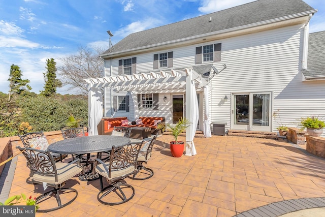 rear view of house featuring a pergola and a patio