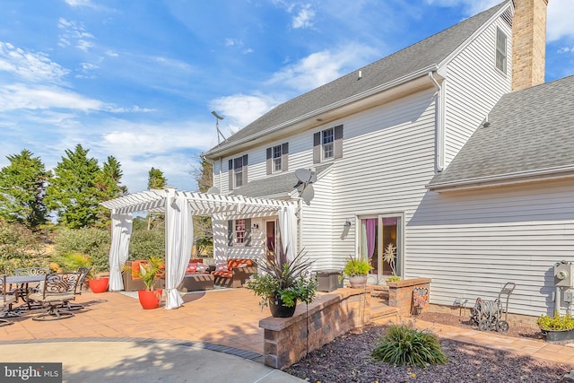 back of property featuring a patio and a pergola