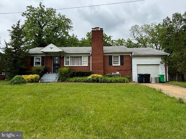 single story home with a chimney, brick siding, a front lawn, and a garage