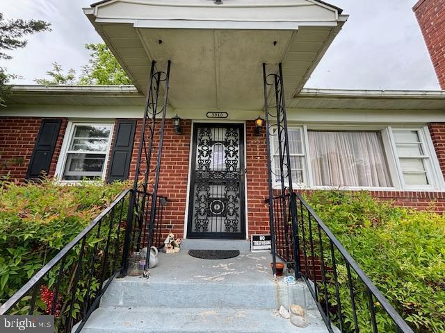 doorway to property featuring brick siding