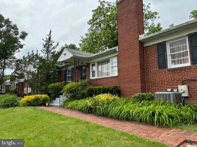 view of front facade with central air condition unit and a front yard