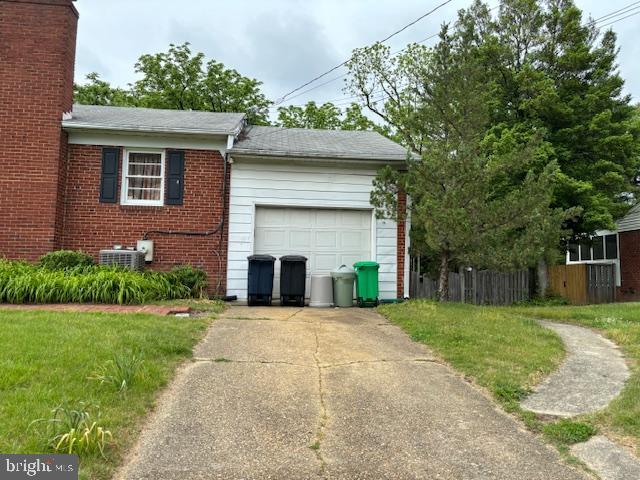 view of property exterior with brick siding, fence, central air condition unit, concrete driveway, and an attached garage