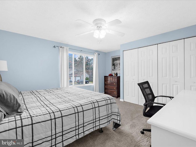 carpeted bedroom with ceiling fan and a textured ceiling