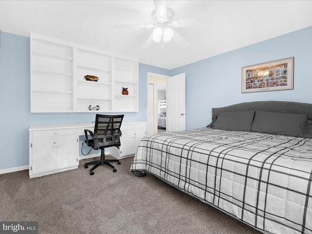 carpeted bedroom featuring built in desk and ceiling fan