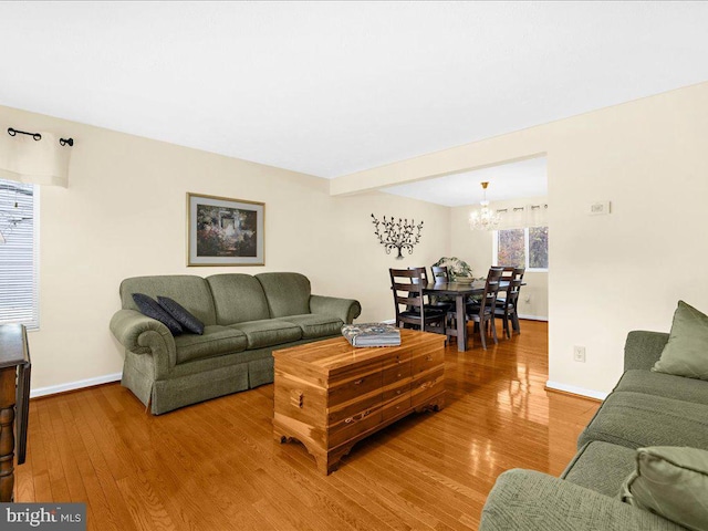 living room with hardwood / wood-style flooring and an inviting chandelier