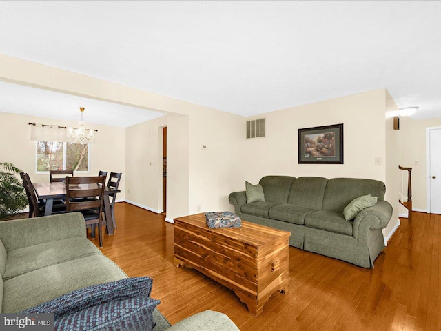 living room with hardwood / wood-style floors and a notable chandelier