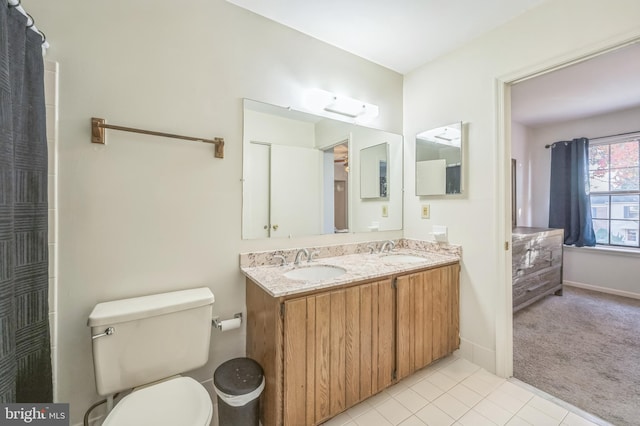 bathroom featuring toilet, vanity, and tile patterned flooring