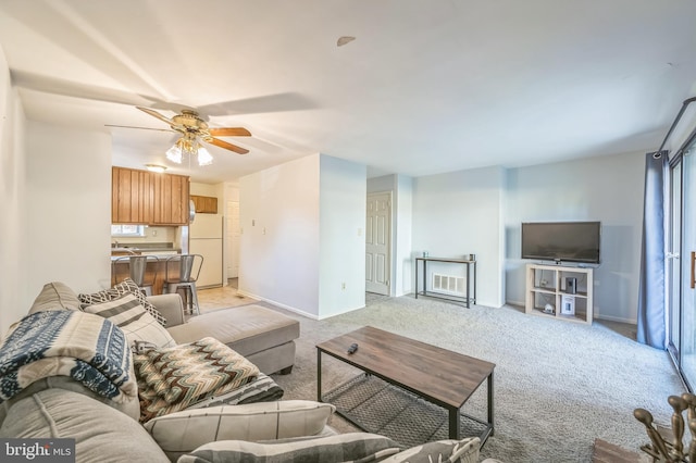 carpeted living room with ceiling fan