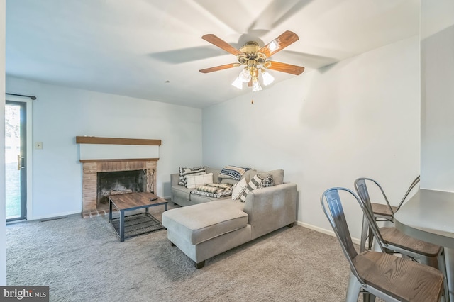 living room featuring ceiling fan, carpet flooring, and a brick fireplace