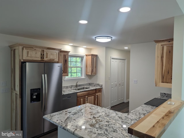 kitchen with light stone counters, stainless steel appliances, dark hardwood / wood-style flooring, sink, and kitchen peninsula