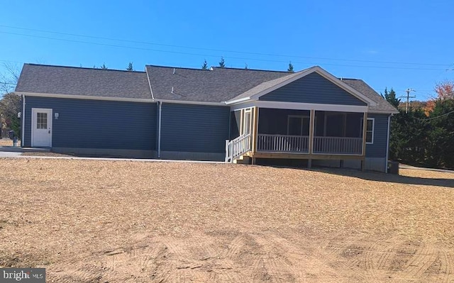 rear view of house featuring a sunroom