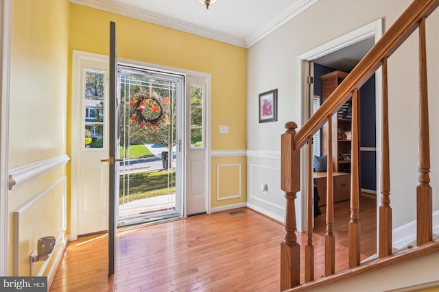 entryway featuring crown molding and light hardwood / wood-style floors