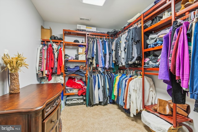 walk in closet featuring light carpet