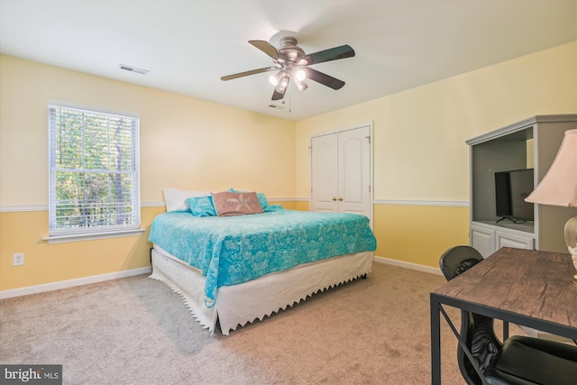 bedroom featuring light carpet, a closet, and ceiling fan