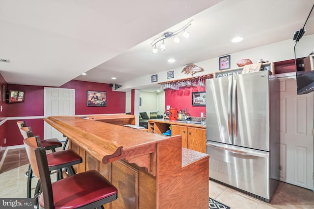 kitchen featuring stainless steel fridge and light tile patterned flooring