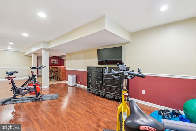 workout room featuring bar and hardwood / wood-style flooring