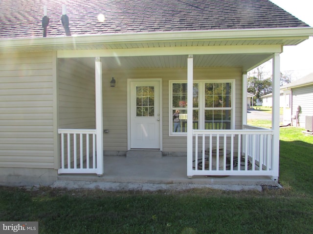 entrance to property with a yard and covered porch