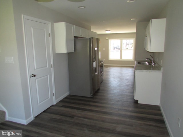 kitchen with white cabinets, stainless steel appliances, sink, and dark hardwood / wood-style flooring