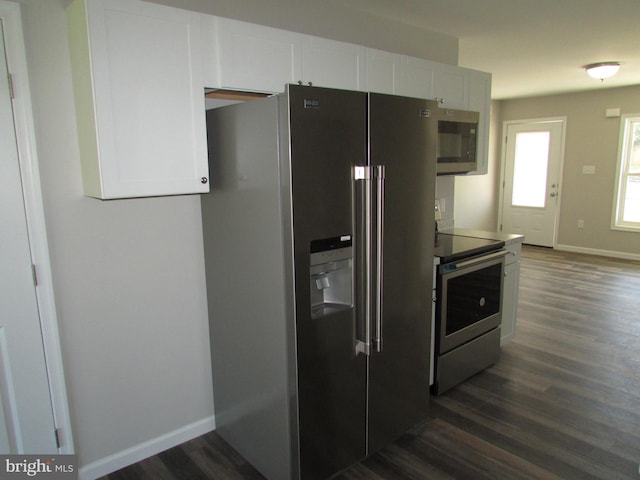 kitchen featuring white cabinets, stainless steel appliances, and dark wood-type flooring