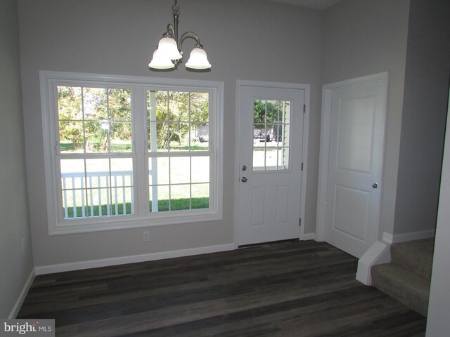 doorway to outside with a chandelier and dark hardwood / wood-style flooring