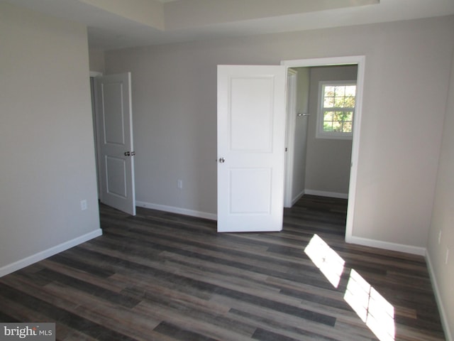 unfurnished bedroom with dark hardwood / wood-style flooring