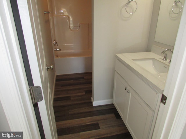 bathroom featuring vanity, hardwood / wood-style floors, and bathtub / shower combination