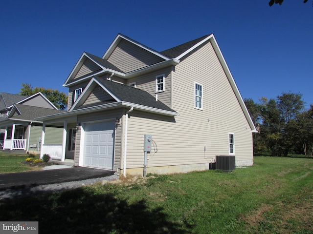 view of side of property featuring central AC, a lawn, and a garage