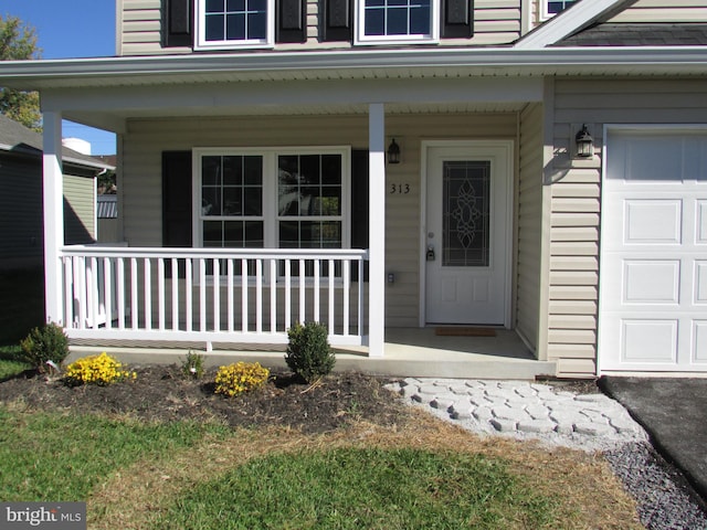 entrance to property with covered porch and a garage