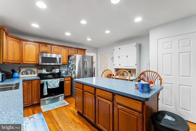 kitchen featuring a kitchen island, stainless steel appliances, and light hardwood / wood-style floors