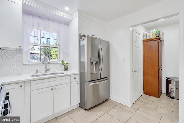 kitchen with range, white cabinets, sink, stainless steel fridge with ice dispenser, and backsplash