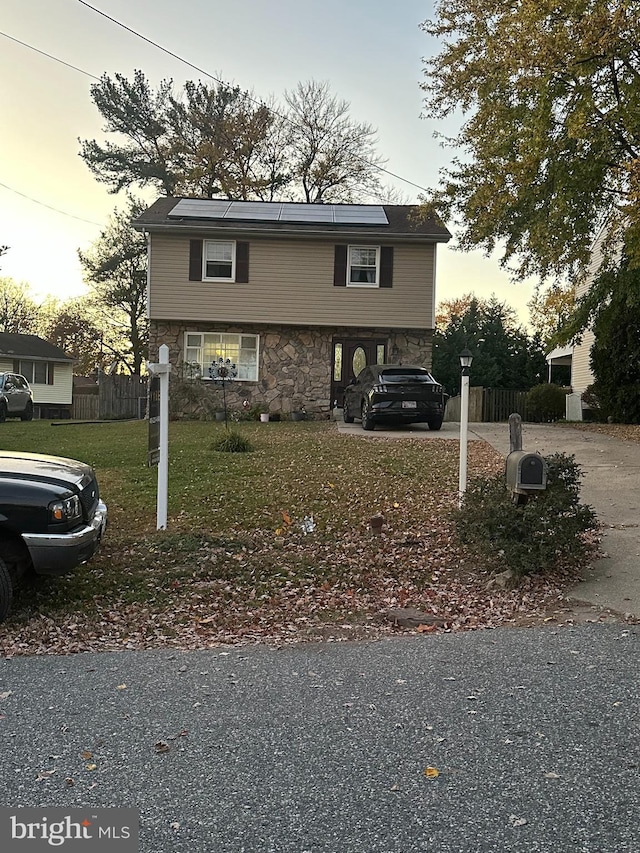 raised ranch with a lawn and a carport