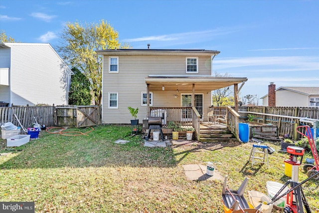 rear view of house with a lawn and a deck