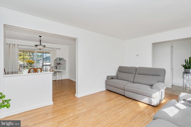 living room with light hardwood / wood-style flooring and a notable chandelier