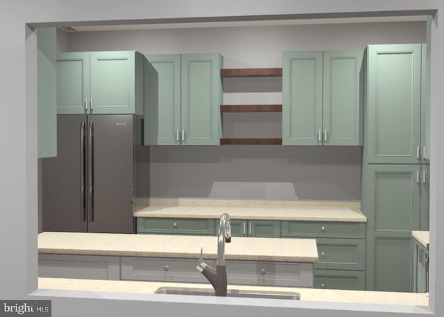 kitchen with open shelves, light countertops, freestanding refrigerator, and green cabinetry