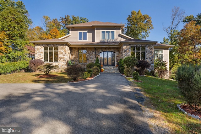 prairie-style house featuring a porch and a front lawn