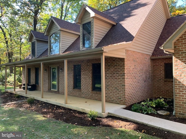 view of property exterior with a patio area and covered porch