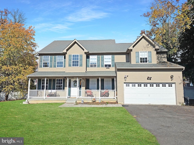 view of front of house featuring a front lawn, covered porch, and a garage