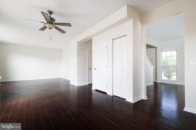 unfurnished room featuring dark wood-type flooring and ceiling fan