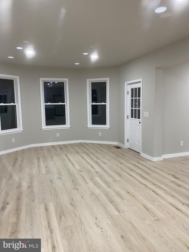 empty room with light hardwood / wood-style flooring